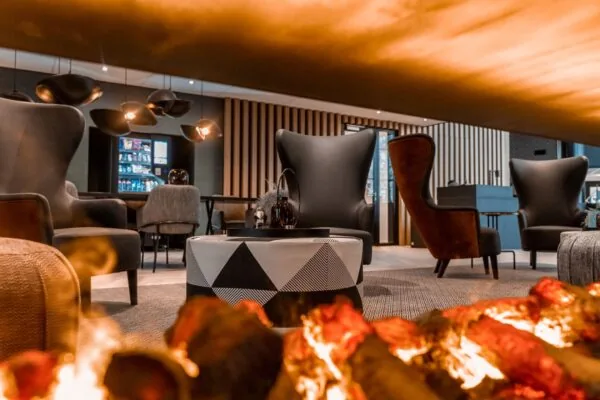 Moderne en sfeervolle loungehoek met designmeubilair en haardvuur in een kantoorruimte aan de Reitscheweg 1.