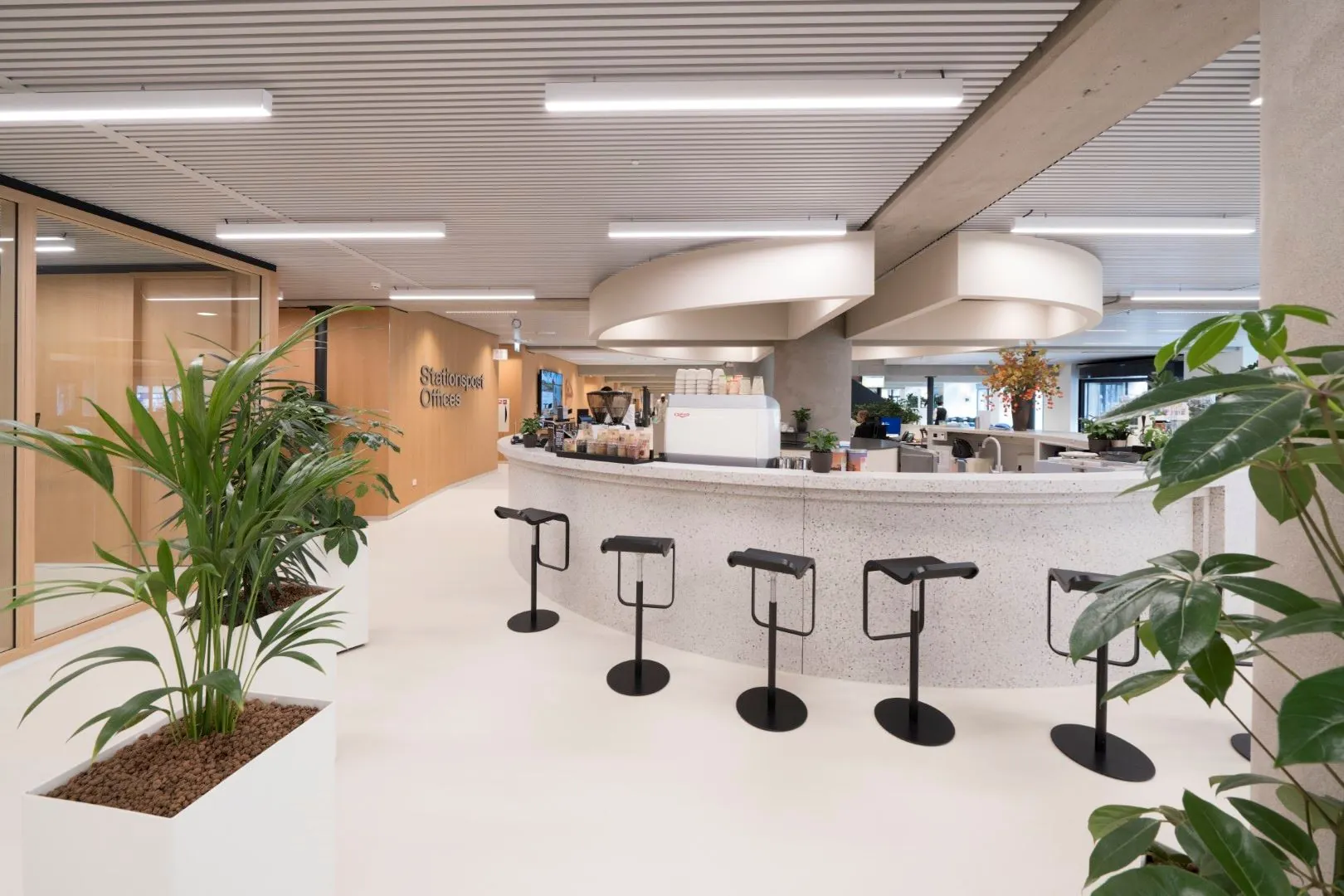 Moderne kantoorruimte aan de Wardropstraat 5 met een open koffiebar, strakke inrichting en veel groen.