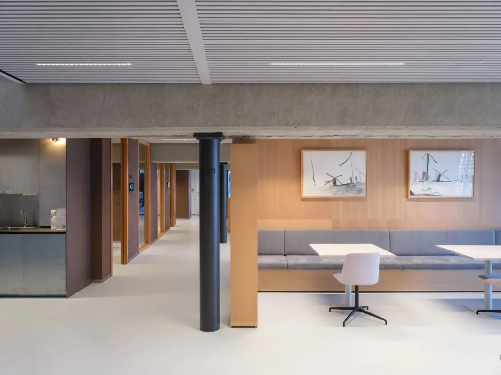 Moderne kantoorruimte aan de Wardropstraat 5 met strakke werkplekken, zithoek en kunst aan de muur.