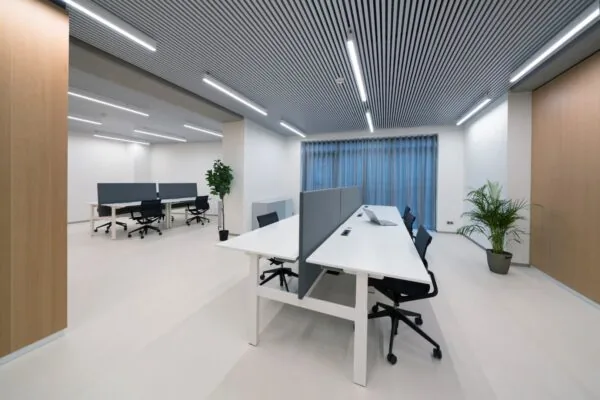 Moderne en lichte kantoorruimte aan de Wardropstraat 5 met werkplekken, scheidingspanelen, bureaustoelen en kamerplanten.