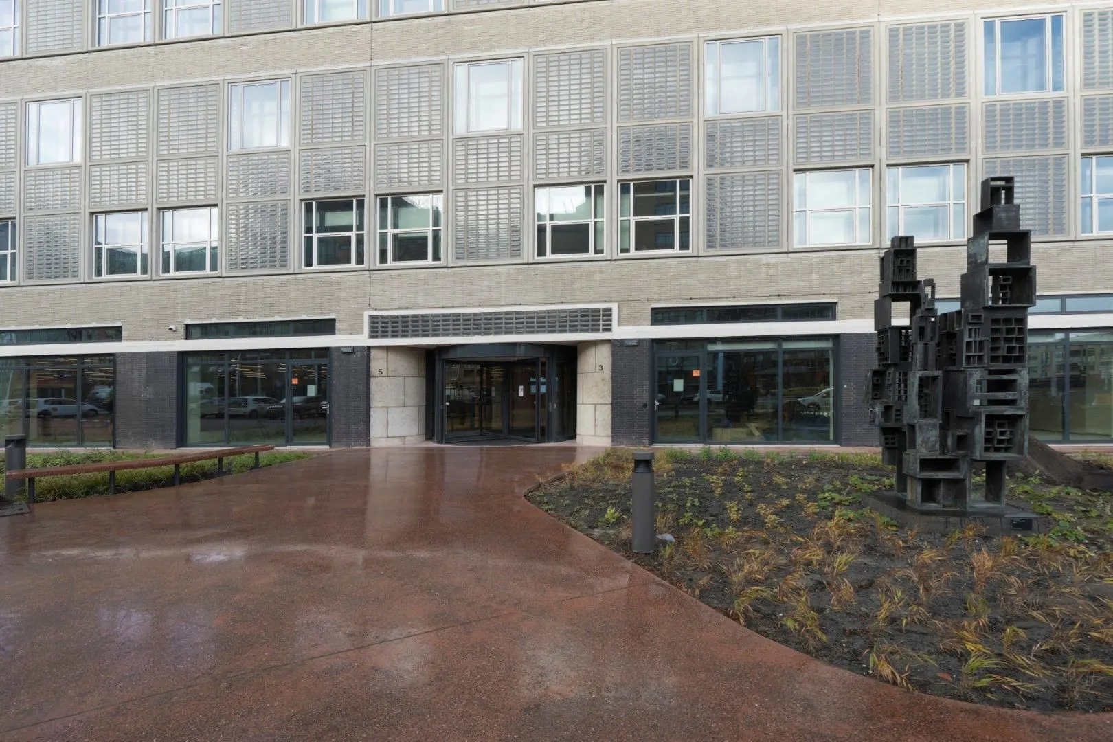 Ingang van het kantoorgebouw aan de Wardropstraat 5 met moderne kunstsculptuur op de voorgrond.