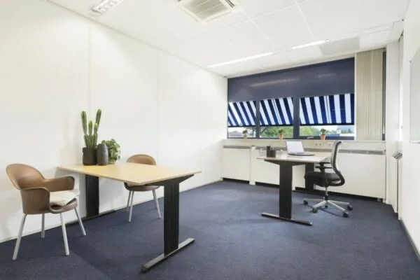 Moderne, lichte kantooruimte in Markerkant Almere met twee bureaus, kamerplanten en uitzicht op blauwe zonwering.