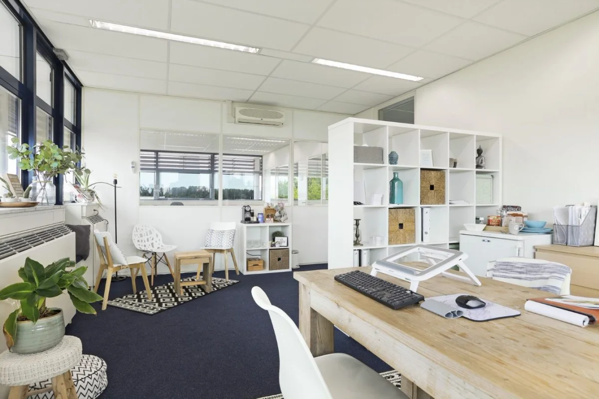 Moderne, lichte kantooruimte in Markerkant Almere met houten bureau, open kast en zithoek.