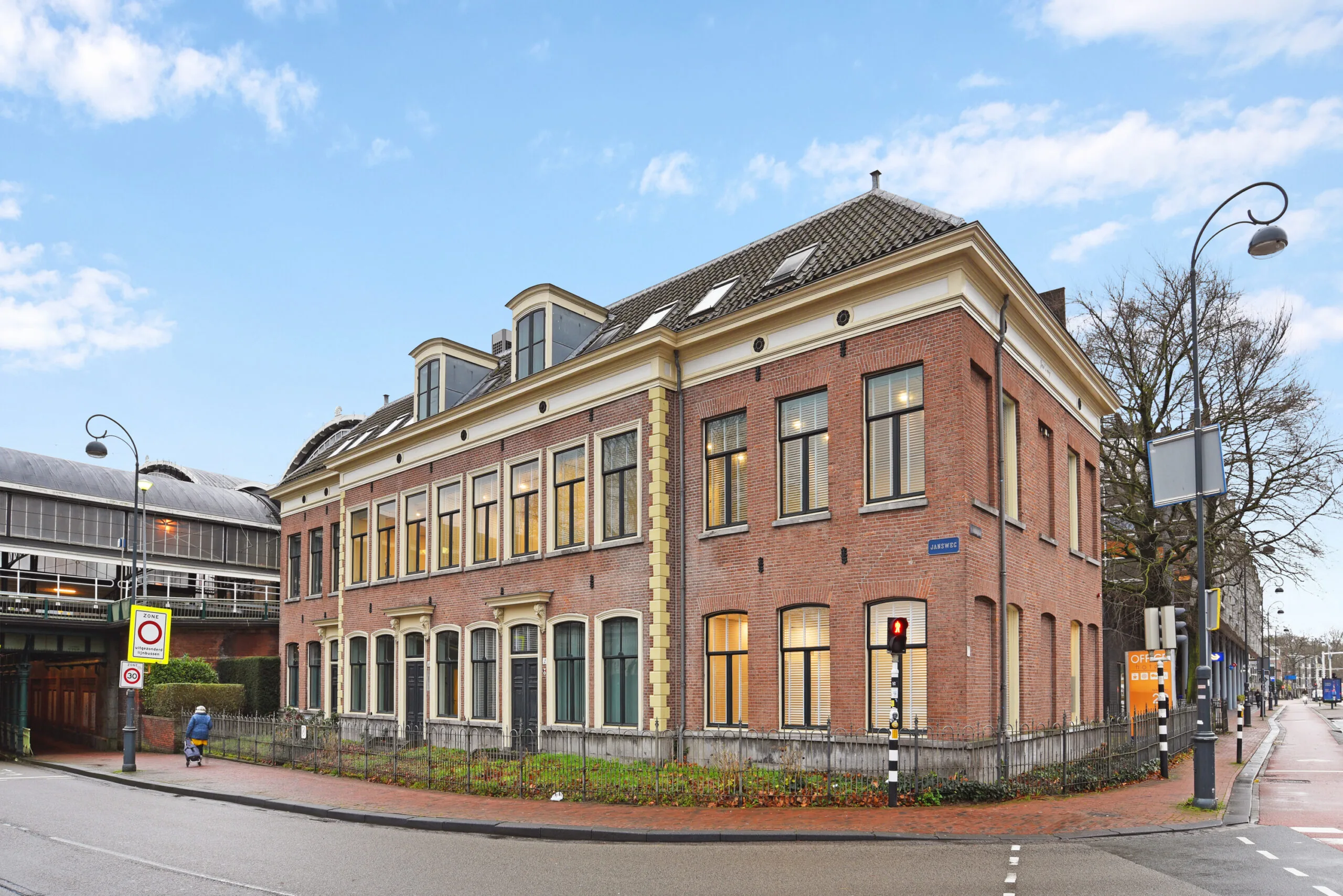 Historisch hoekpand aan het Kennemerplein 20 in Haarlem, naast het station en aan de straat Jan Wijnstraat, met roodbruine bakstenen gevel en hoge ramen.