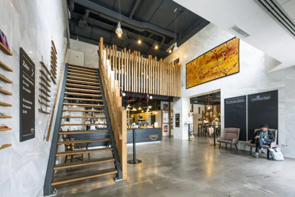 Moderne, open lobby van Kronenburg 010 met houten trap, kunst aan de muur en zitgedeelte met wachtruimte.