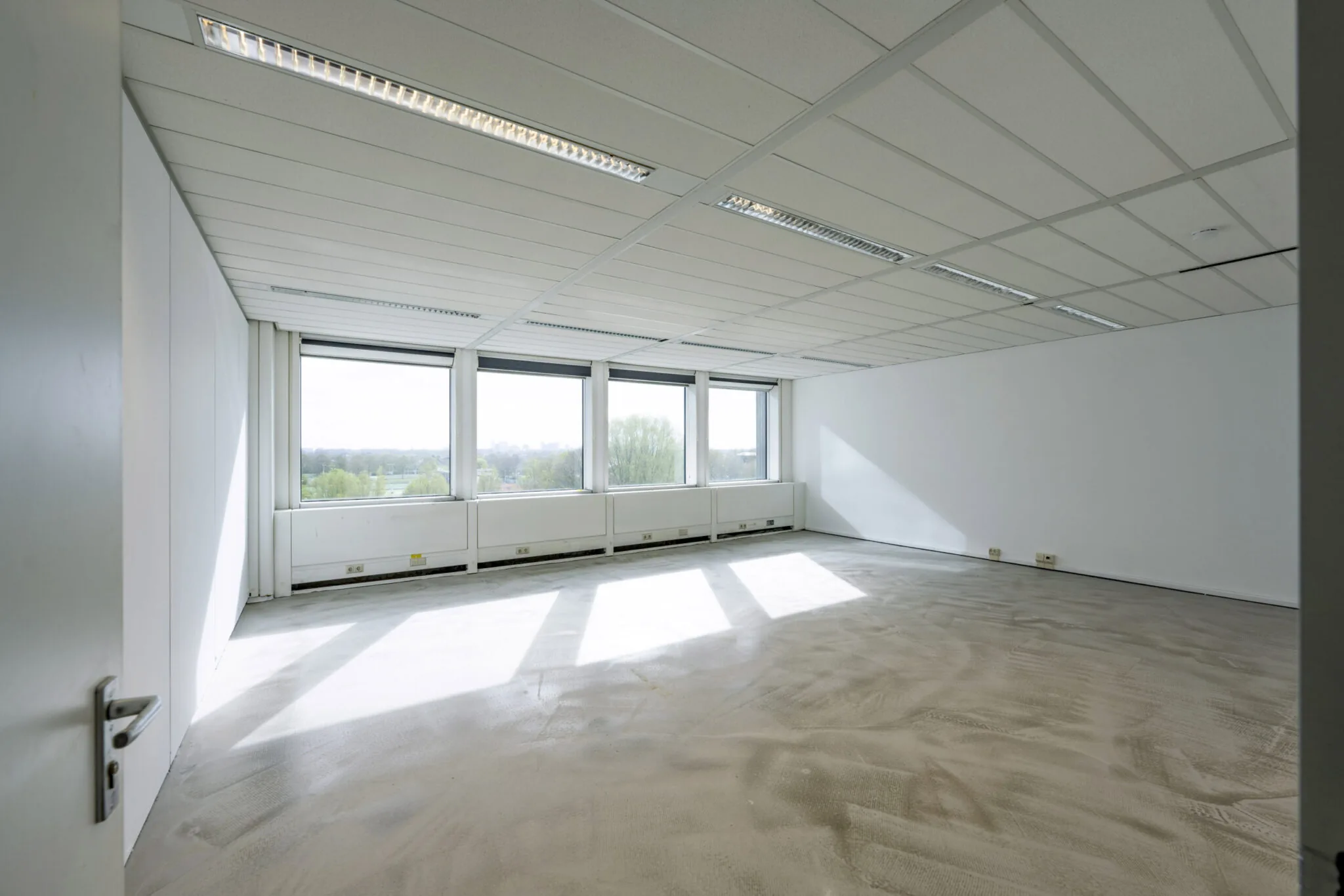 Leeg kantoorruimte met grote ramen in het kantoorcomplex Kronenburg, ontwerp Paul Starink.