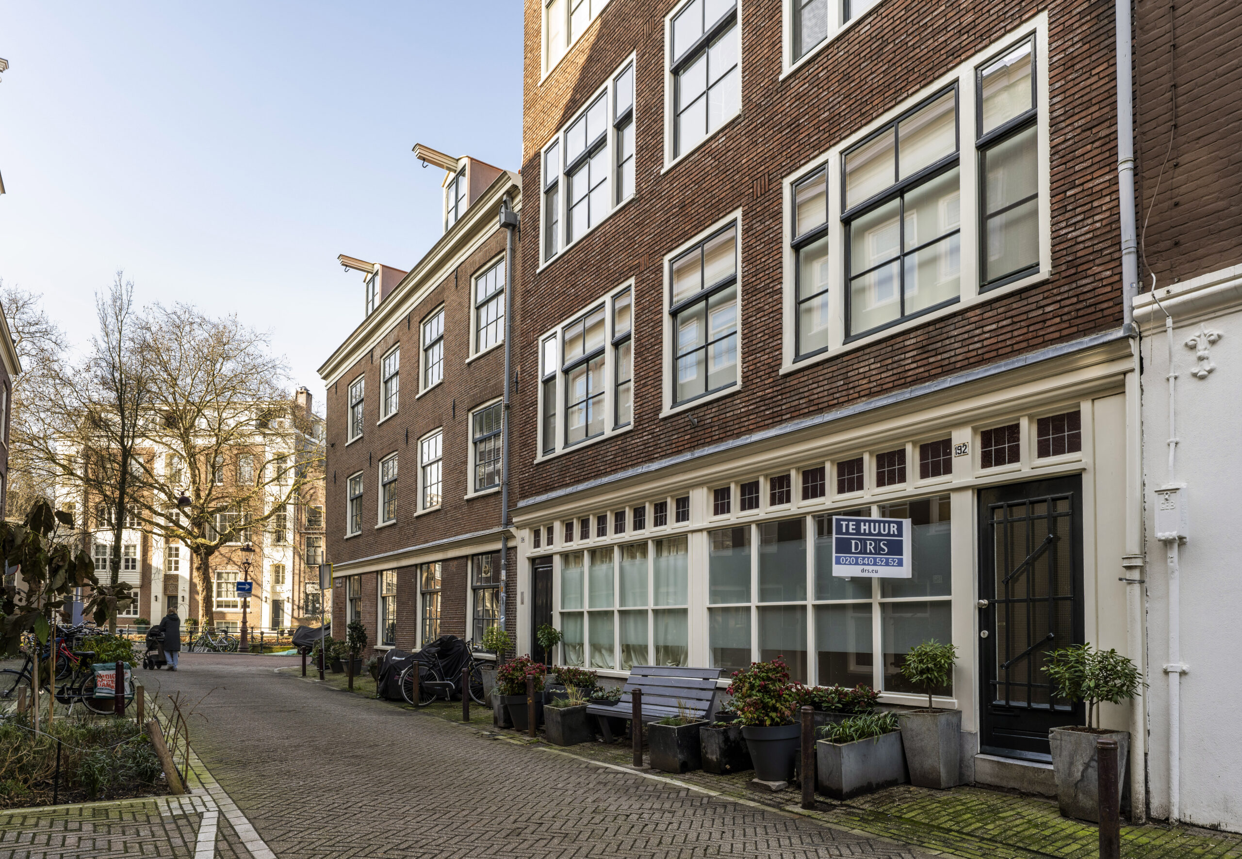 Gevelaanzicht van een te huur aangeboden pand aan de Leliestraat in Amsterdam met bakstenen muren en witte kozijnen.
