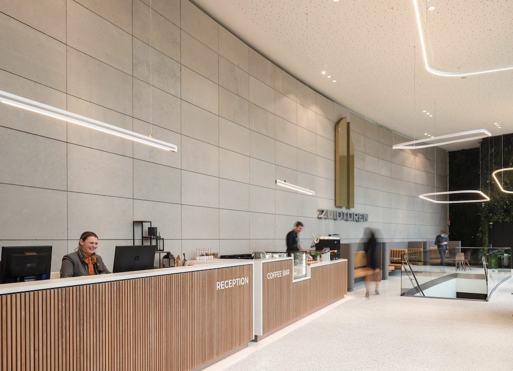 Moderne lobby van het gebouw 'ZUIDTOREN' met een receptiebalie, koffiebar en loungeruimte.
