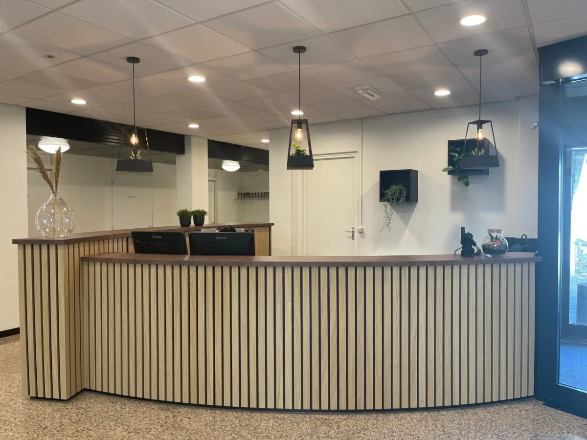 Receptiebalie met houten lamellen in de entree van Rent an Office Markerkant in Almere.