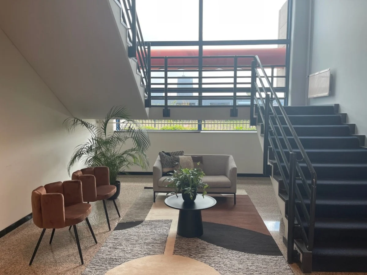 Moderne wachtruimte bij de trap in kantoorpand Markerkant in Almere, met zitmeubels, planten en grote ramen.