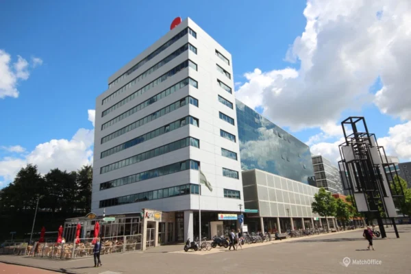 Modern office building in Rotterdam Prins Alexander with outdoor seating and a public square.