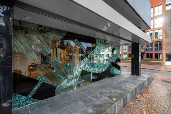 Glazen kunstwerk met abstracte vormen in de etalage van een gebouw aan de ’s-Gravelandseweg 9.