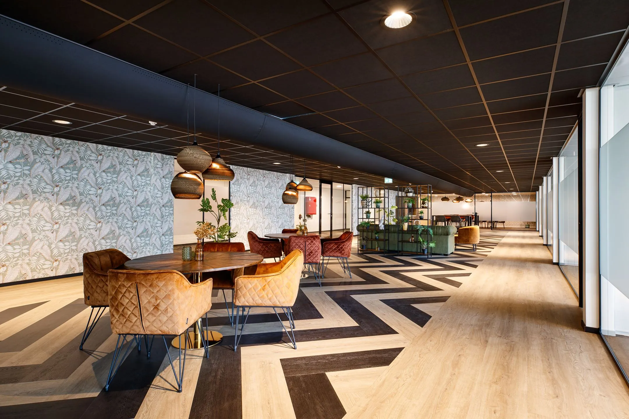 Moderne en sfeervolle kantoorruimte aan de ‘s-Gravelandseweg 9 met houten visgraatvloer, designmeubels en hanglampen.