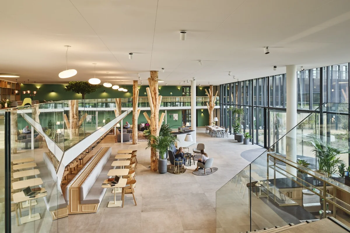 Moderne, open kantoorruimte aan de Van Deventerlaan 31-51 met veel daglicht, groene accenten en natuurlijke houten elementen.