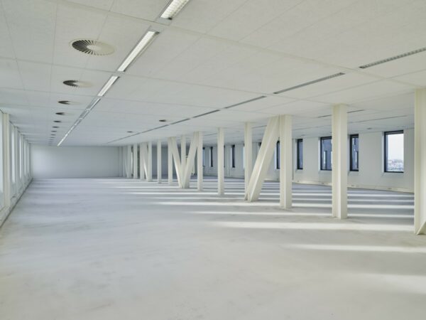 Lichte, lege kantoorruimte op Van Deventerlaan 31-51 met witte pilaren en grote ramen.