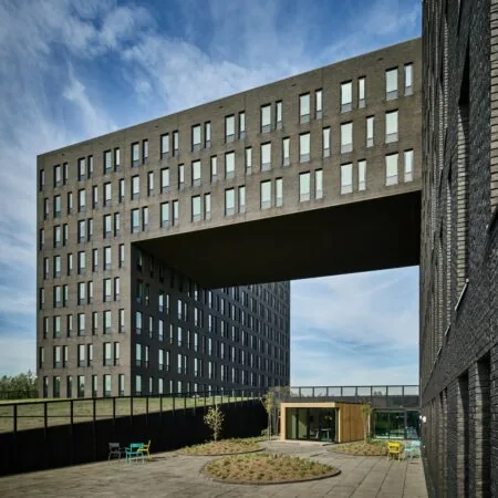 Moderne kantoorgebouwen aan de Van Deventerlaan 31-51 met opvallende luchtbrug en binnenplaats met zitgelegenheid.