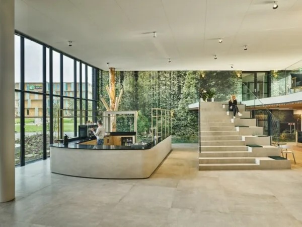 Moderne en lichte lobby van Van Deventerlaan 31-51 met een zittribune, werkplek en uitzicht op een Holiday Inn Express gebouw.