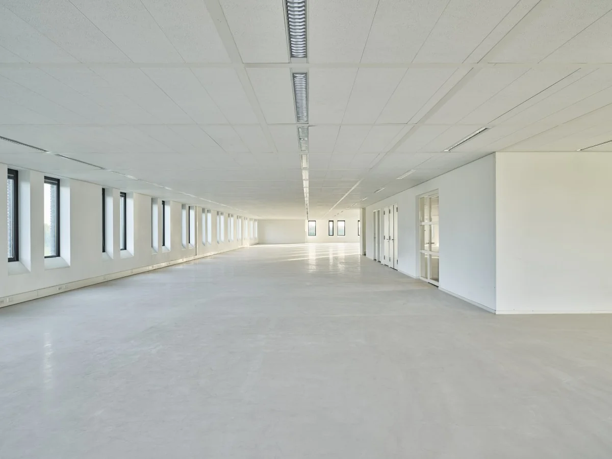 Lichte, leegstaande kantoorruimte aan de Van Deventerlaan 31-51 met lange rijen ramen en systeemplafond.