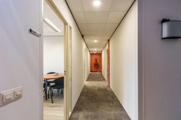 Verlichte kantoorruimte met een gang en een open deur naar een vergaderruimte aan de Noordvest in Schiedam.