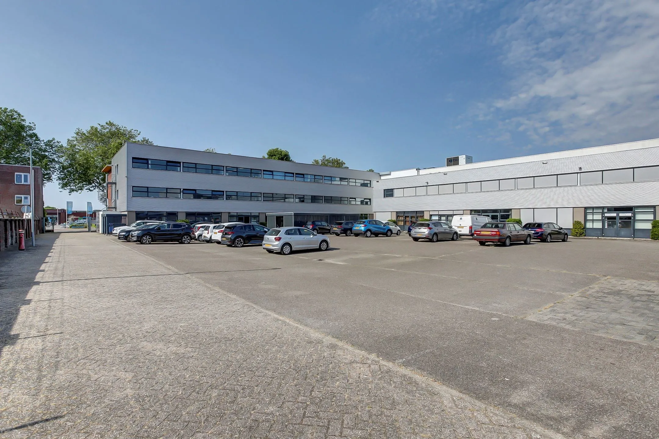 Kantoorgebouw aan de Groenestraat 294 met ruime parkeerplaats op een zonnige dag.