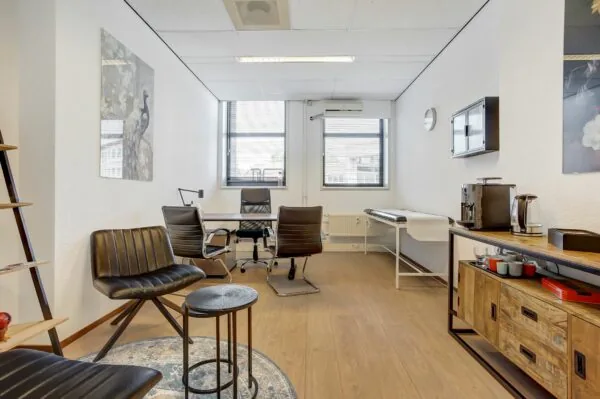 Modern ingerichte kantoorruimte aan de Groenestraat 294 met bureau, zithoek, koffiecorner en twee ramen die zorgen voor veel daglicht.