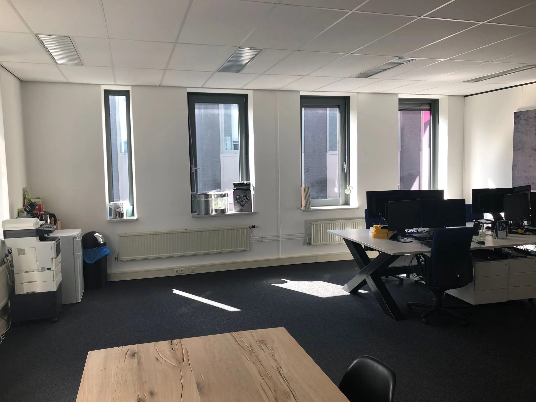 Licht en modern kantoor in Kerkenbos 1033-1037 met werkplekken, ramen en een multifunctionele printer.