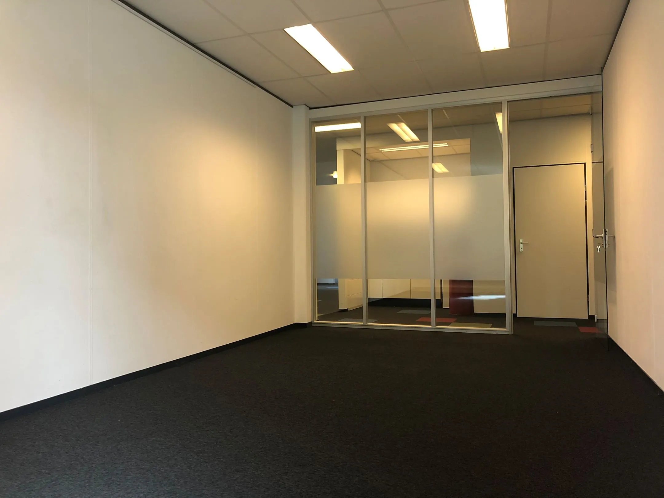 Leeg kantoorruimte in kantoorpand Kerkenbos 1033-1037 met glazen scheidingswand en deur.