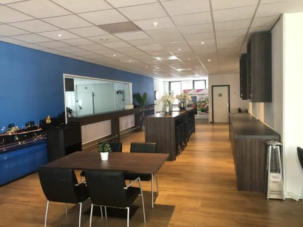 Moderne, sfeervol ingerichte horecaruimte in het bedrijfsverzamelgebouw Kerkenbos 1033-1037 met houten vloer, zithoeken en grote wandfoto van Nijmegen.