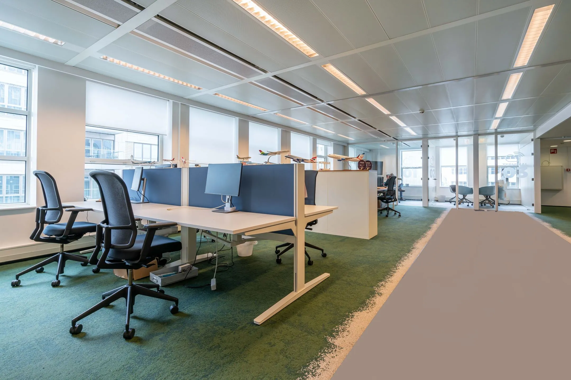 Moderne kantoorruimte aan de Turfmarkt 104 met werkplekken, bureaustoelen en vergaderruimtes met glazen wanden.