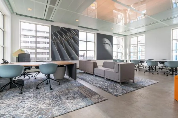 Moderne, lichte kantoorruimte aan de Turfmarkt 104 met flexibel meubilair, grote ramen en luchtvaartthema in het interieur.