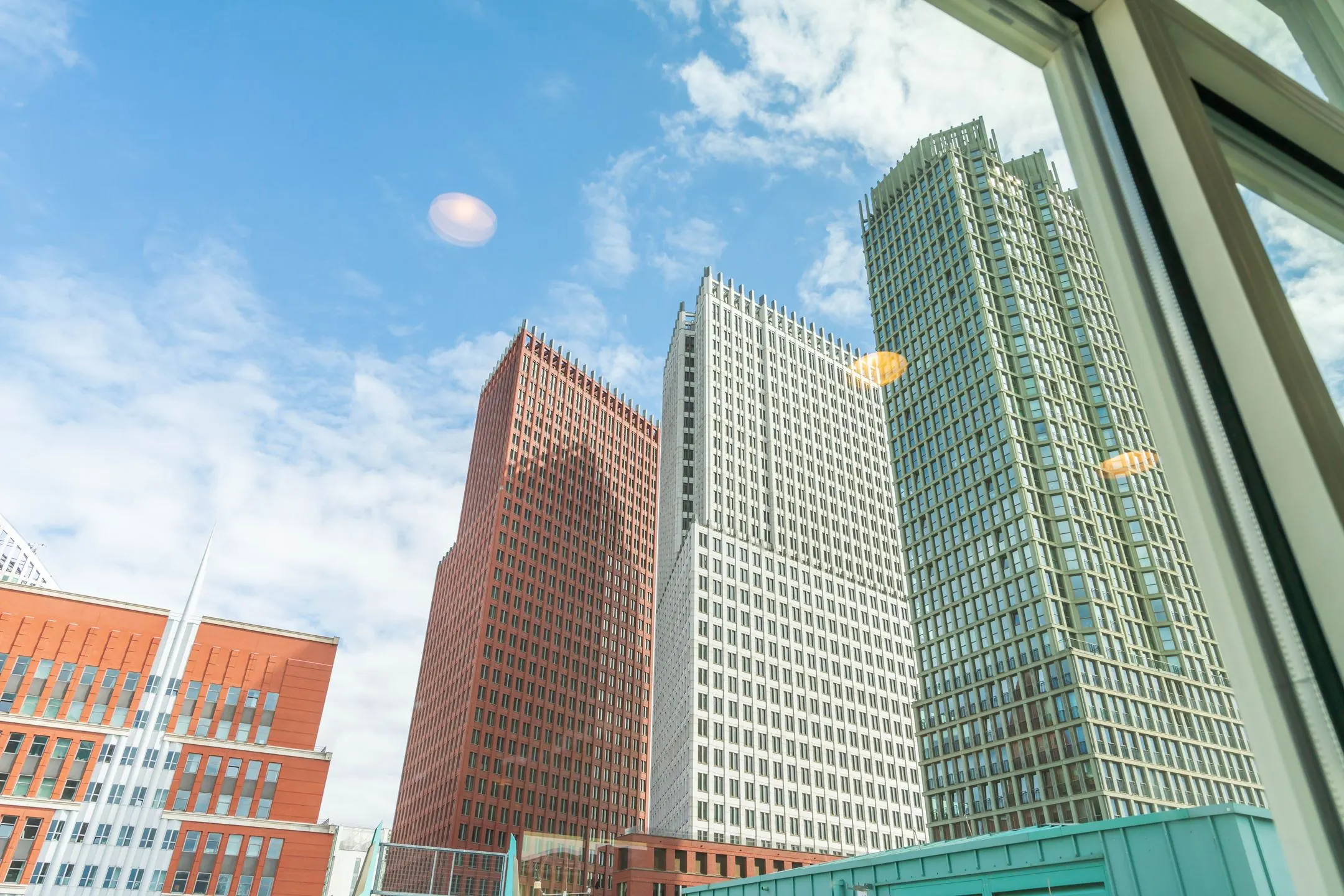 Uitzicht vanuit een kantoorraam op de moderne kantoorgebouwen aan de Turfmarkt 104 in Den Haag.