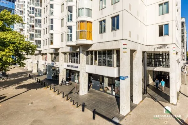 Vooraanzicht van het gebouw Weena Flat in Rotterdam met diverse winkels, waaronder KIKI NAILBAR, op de begane grond.