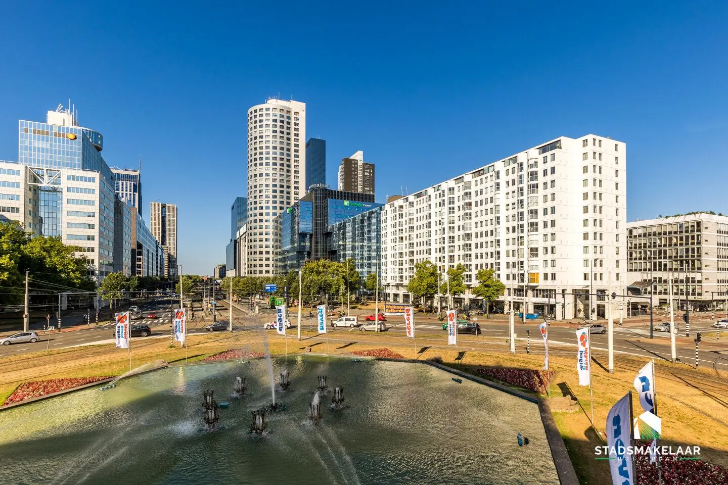 Modern kantoorgebouw aan het Weena 81 in Rotterdam met fontein en stadsverkeer op de voorgrond.