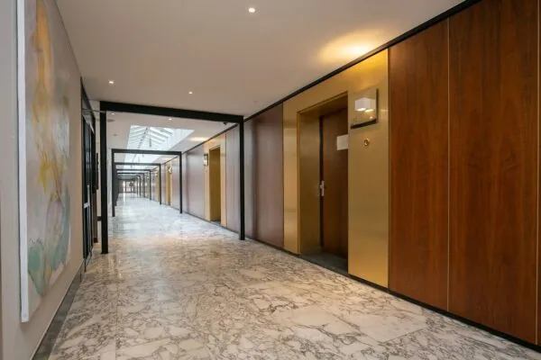 Luxe marmeren gang in kantoorgebouw Weena 81 met houten wandbekleding en deuren.