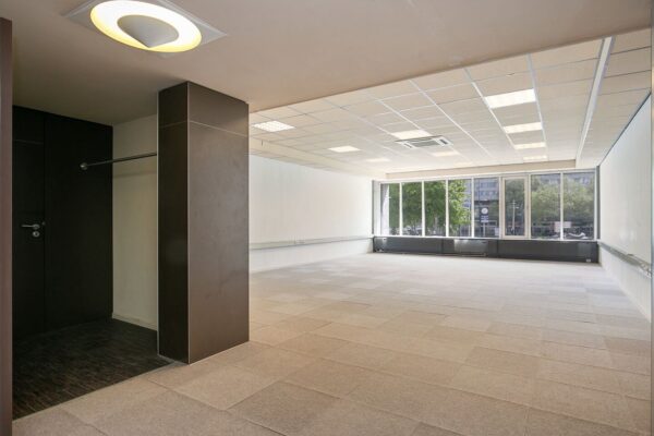 Leeg, modern kantoorruimte in Weena 81 met grote ramen en systeemplafond.