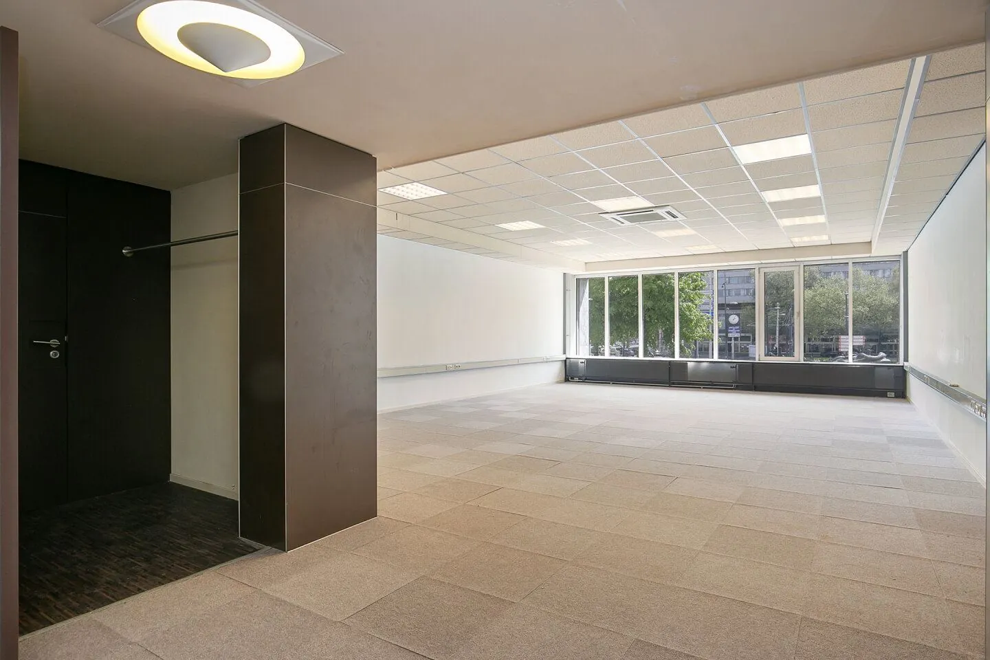 Leeg, modern kantoorruimte in Weena 81 met grote ramen en systeemplafond.