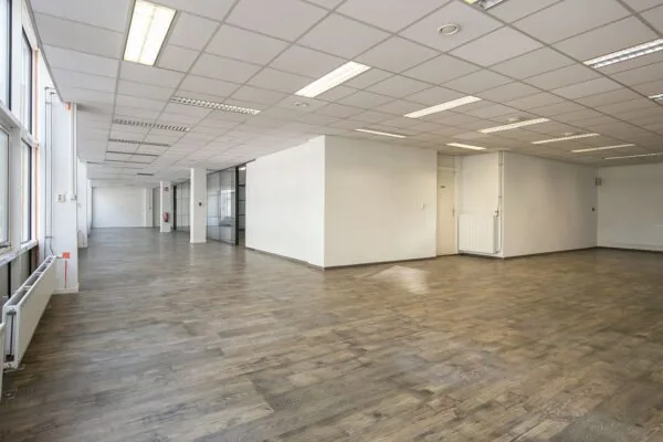 Ruime, lege kantoorruimte in Weena 81 met houten vloer, systeemplafond en grote ramen.